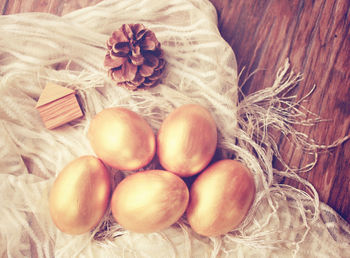 Directly above shot of gold easter eggs on fabric at table