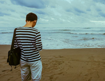 Rear view of man standing at beach