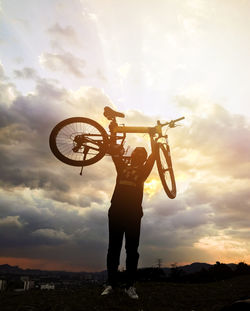 Full length of man with bicycle standing against sky during sunset