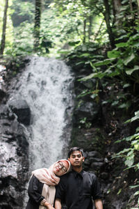 Young man standing on rock in forest