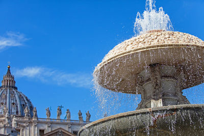 Low angle view of fountain against blue sky