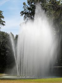 Scenic view of fountain against trees