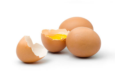 Close-up of broken egg against white background