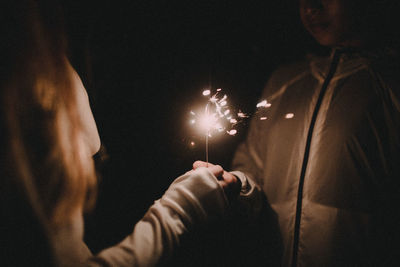 Close-up of hand holding leaf at night