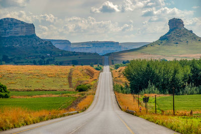 Empty road along countryside landscape