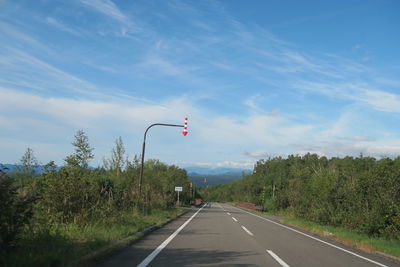 Road amidst trees against sky