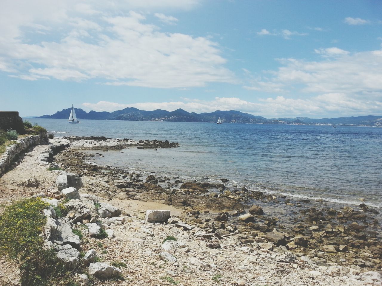 water, sky, tranquil scene, beach, tranquility, sea, scenics, shore, beauty in nature, mountain, nature, sand, cloud - sky, rock - object, idyllic, cloud, day, coastline, non-urban scene, remote