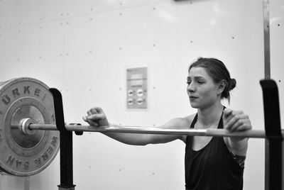 Young woman exercising in gym preparing to lift