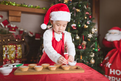 Young girl preparing mince pie for celebrating christmas party