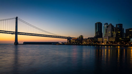 Bay bridge against clear sky at sunrise