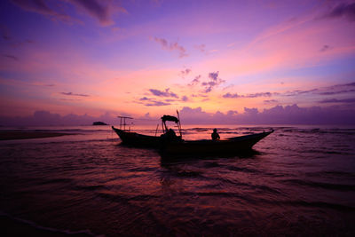 Silhouette boat in sea against sky during sunset