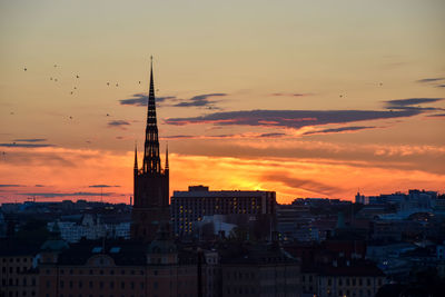 Buildings in city against sky during sunset