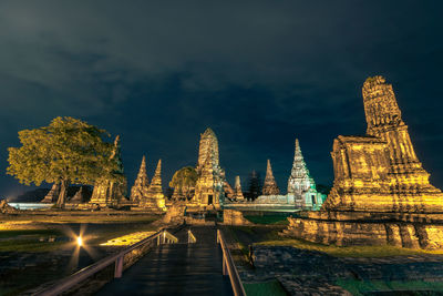 Illuminated temple amidst buildings against sky