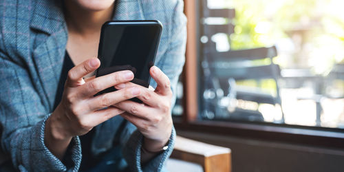 Midsection of woman using mobile phone