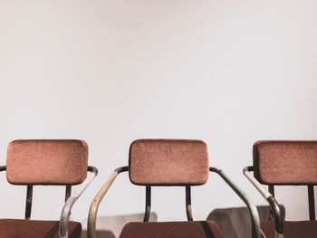 Close-up of empty chairs against white background