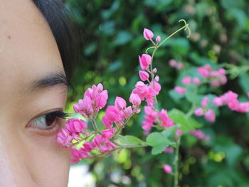 Close-up of woman by pink flowers