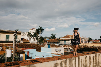 Woman standing by buildings against sky