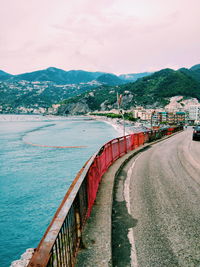 Scenic view of city by sea against sky