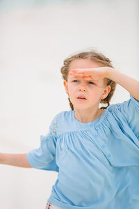 Portrait of young woman standing against wall