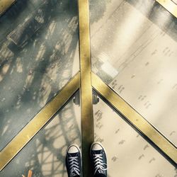 Low section of man standing on tiled floor