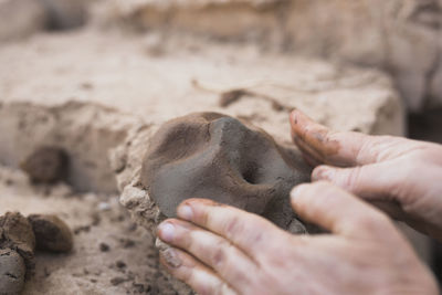 Cropped hands making face with clay