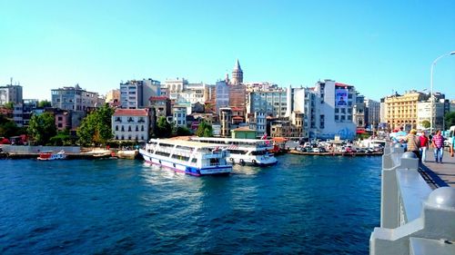 Boats in river with cityscape in background