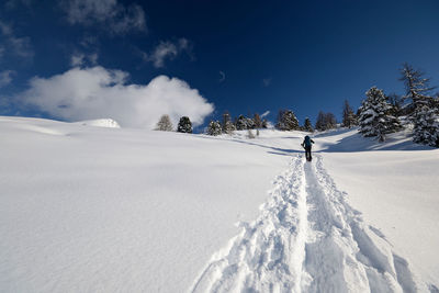 Person skiing on snowcapped mountain against sky