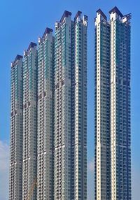 Low angle view of modern building against blue sky