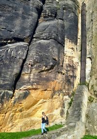 Full length rear view of woman standing on rock