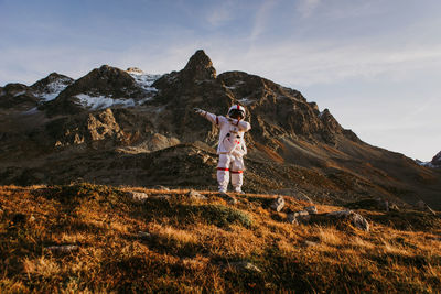 Man standing on rock in mountains against sky