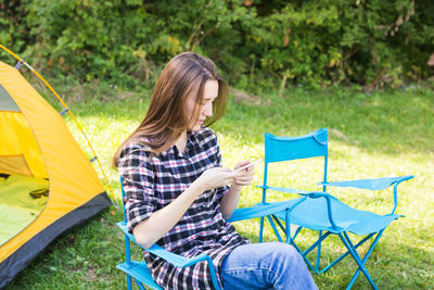 Midsection of man holding umbrella while sitting on land