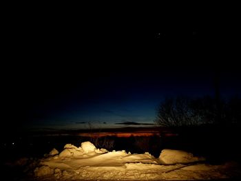 Scenic view of beach against clear sky at night