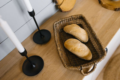 Two french bread rolls in a wicker basket on the scandinavian-style kitchen countertop