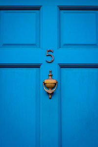 House number 5 on a blue wooden front door in london 
