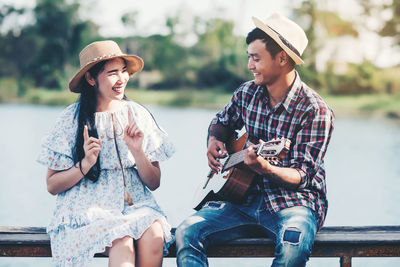 Young woman wearing hat sitting outdoors