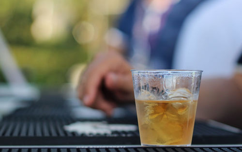 Cropped hand having cocktail in glass on table at party