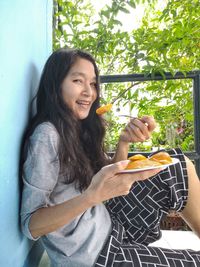 Smiling young woman eating food