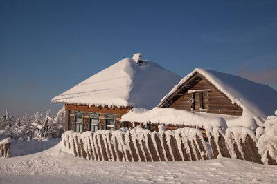 Built structure on snow covered land against sky