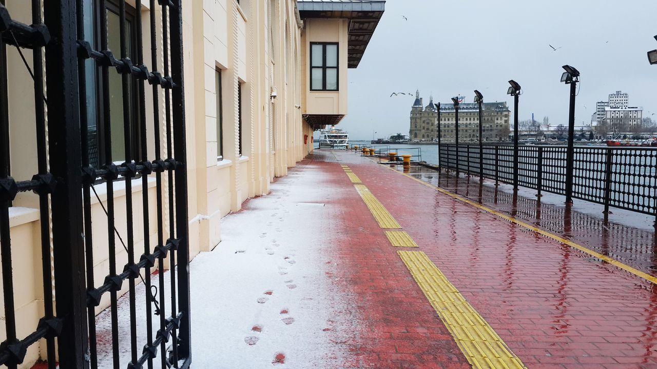 architecture, built structure, the way forward, building exterior, diminishing perspective, railing, city, street light, transportation, vanishing point, street, in a row, building, incidental people, day, outdoors, road, metal, empty, protection