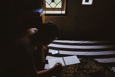 Man writing on note pad in room at home