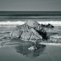 Scenic view of rocks in sea against sky