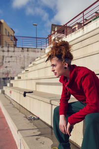 Side view of woman sitting at stadium