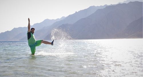 Rear view of man surfing in sea