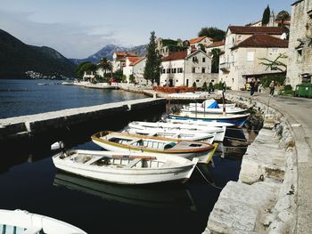 Boats moored at harbor against sky