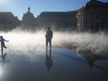 Full length of man standing in city against sky