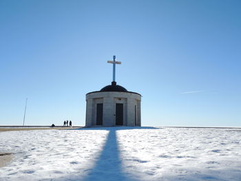 Church by building against clear blue sky