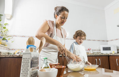 Mother and son preparing food in kitchen