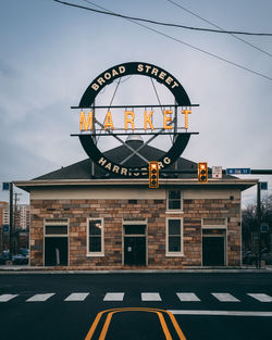 Low angle view of sign on road against sky