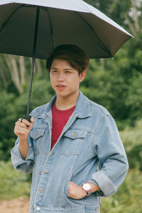 Portrait of young man standing in rain