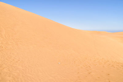 Scenic view of desert against clear blue sky